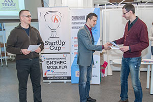 Вячеслав Макович, руководител StartUp Cup St.-Petersburg вручает приз зрительских симпатий Даниилу Чернякову