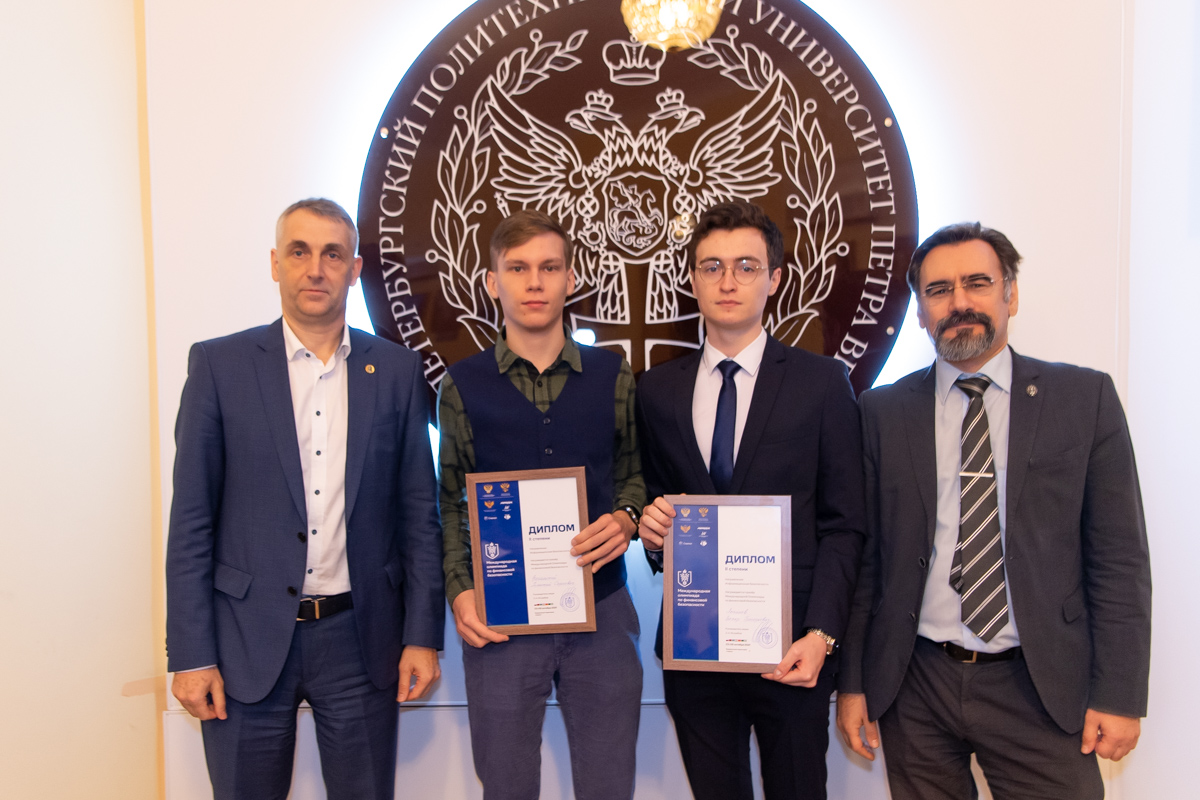 Первый проректор Виталий Сергеев и директор Института кибербезопасности и защиты информации Дмитрий Зегжда с призерами Международной олимпиады по финансовой безопасности 