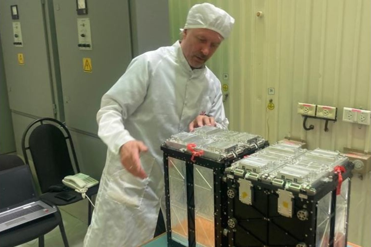 Участник научной группы по разработке наноспутников в Политехе Сергей Волвенко проверяет состояние кубсата, который находится в пусковом контейнере 