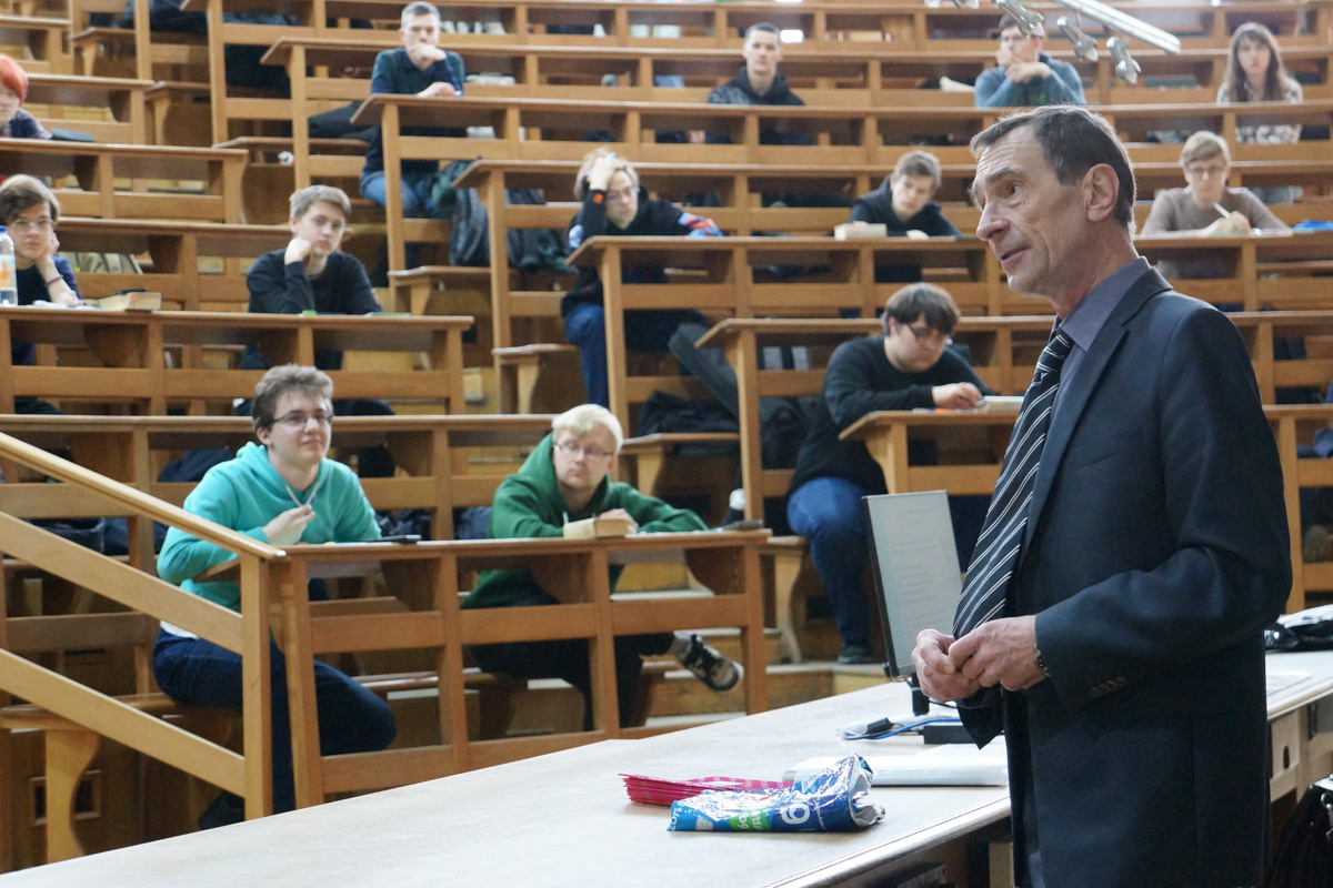 Член организационного комитета Сергей Старовойтов приветствует участников десятой юбилейной физической олимпиады в большой физической аудитории 26 апреля 2025 года 