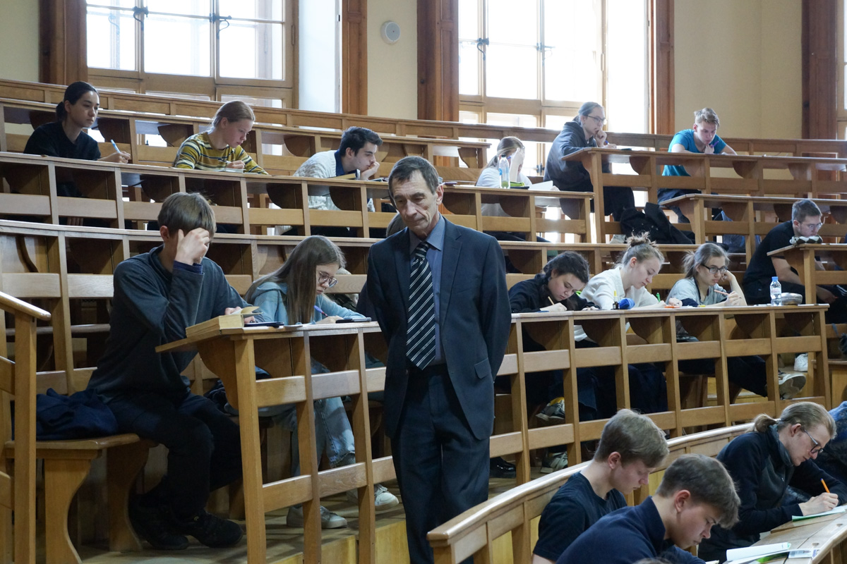 Участники десятой юбилейной физической олимпиады решают задачи в большой физической аудитории 