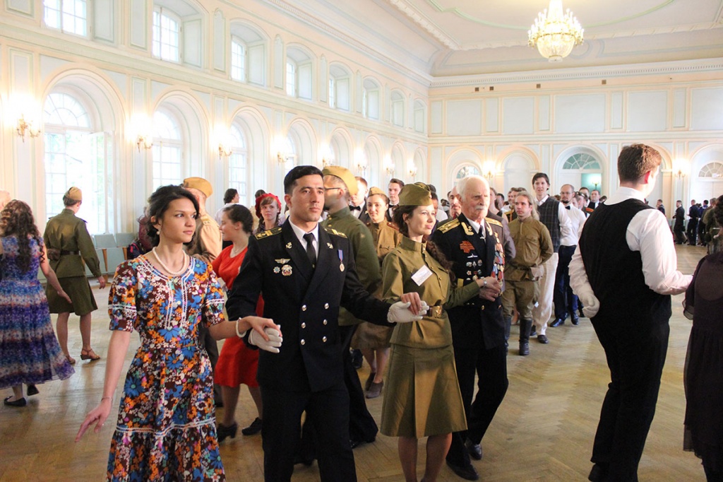 Юноши в военной форме и девушки, одетые по моде 1940-х, прекрасно смотрелись в одном из красивейших парадных залов Петербурга